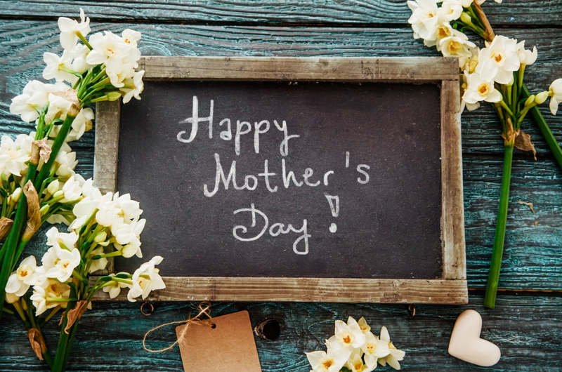 Mothers day sign surrounded by flowers.