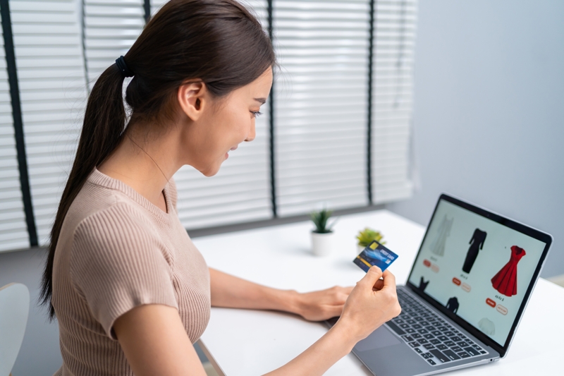 Young woman uses a laptop for shopping.